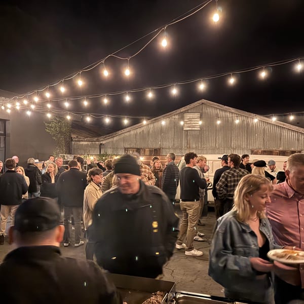 Guests gather under string lights at an outdoor evening event at La Parrilla Taqueria.