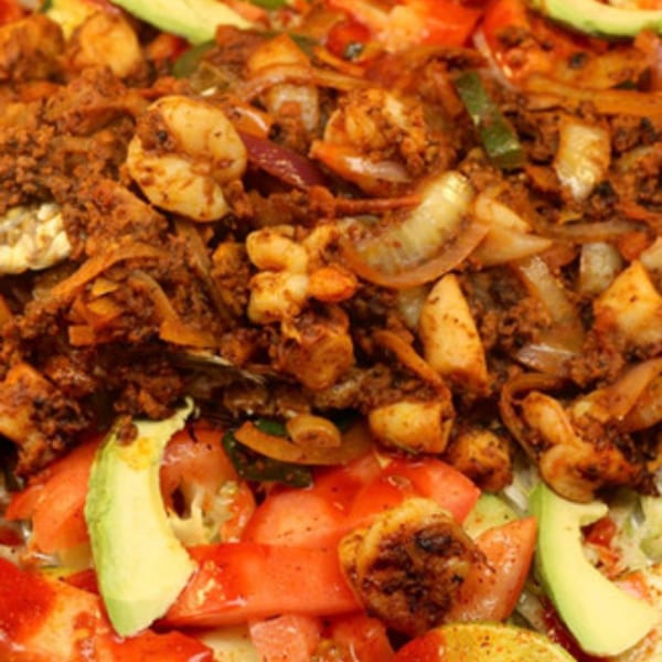 Close-up of La Parrilla Taqueria's Mexican shrimp dish with onions, tomatoes, and avocado.
